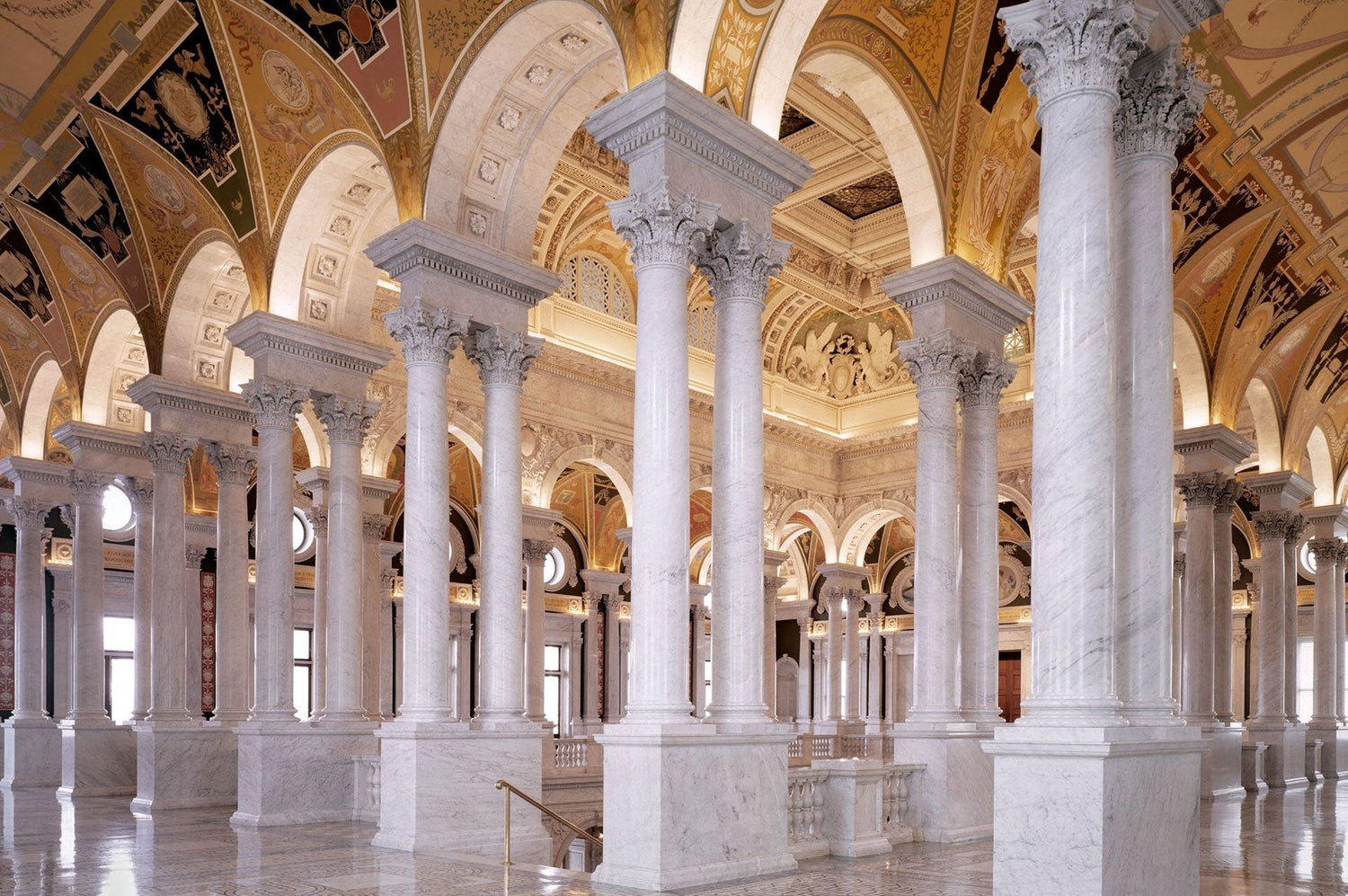 Photo of white matble columns holding up white and golden arches.