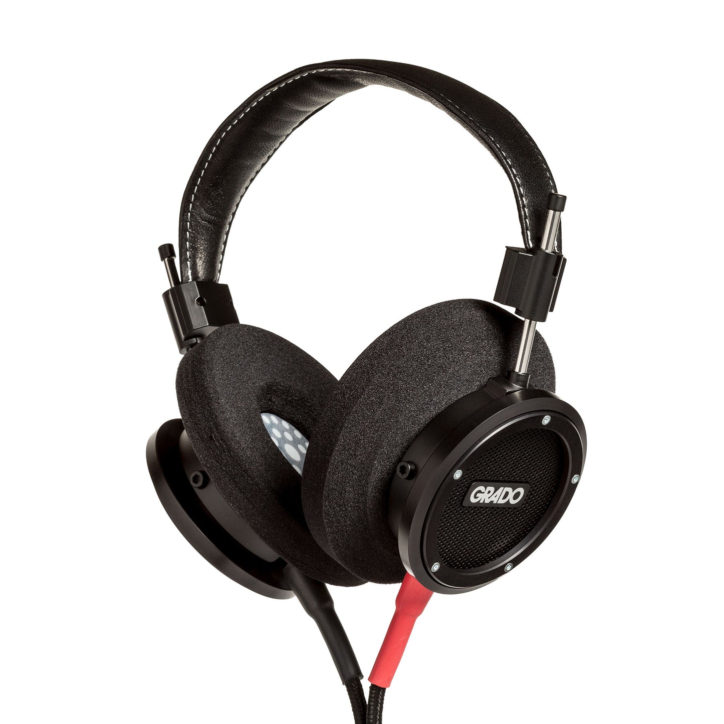 Photo of Grado S750 Headphones on a white background taken from 3/4 view - one ear cup is facing away from view while the other is showing the Grado logo in the center. The red/black cables can be seen coming out of the headphone.