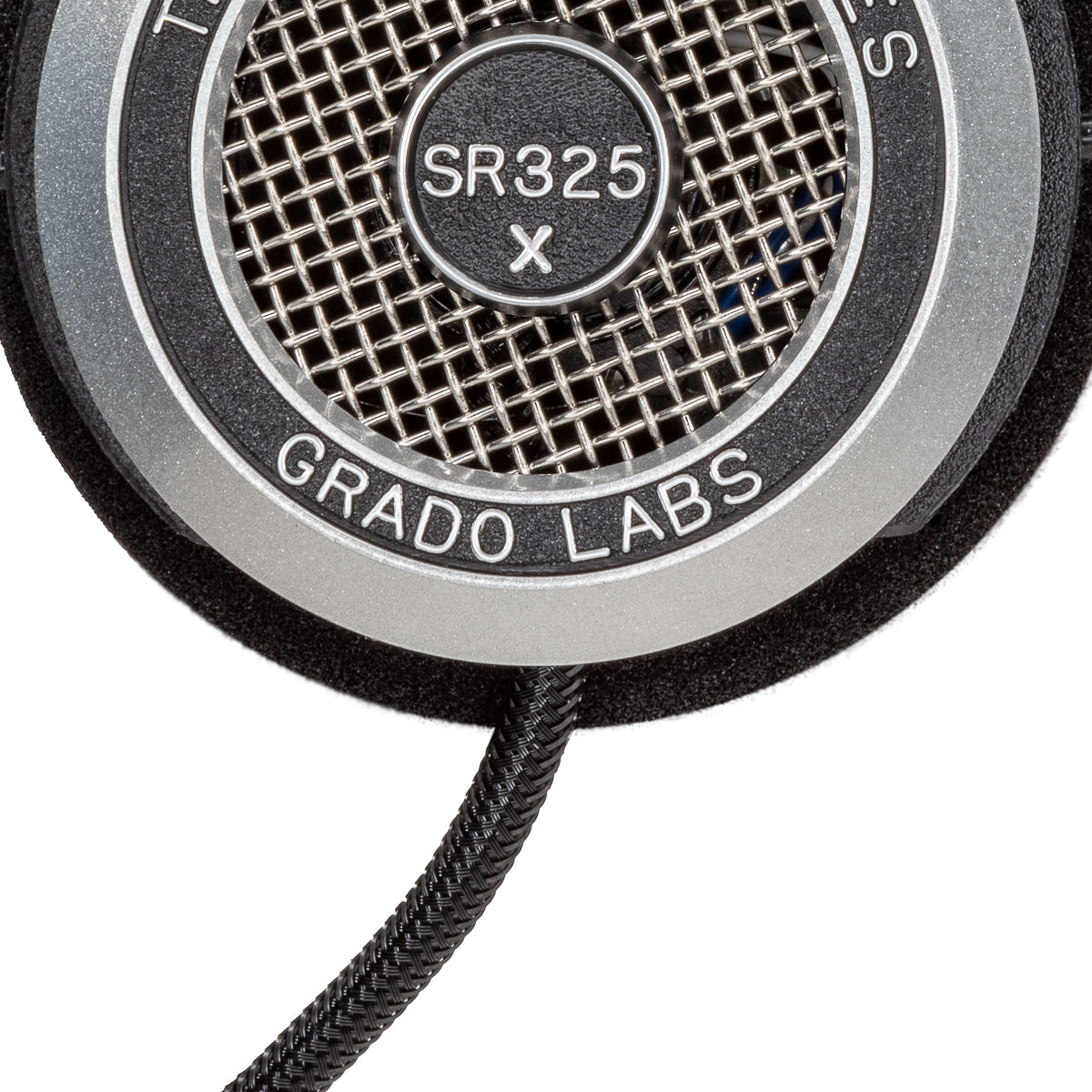 Close up photo of the Grado SR325x Headphones taken from the side - the model name - SR325x - is featured in the center of the ear cup. The Words - The Prestige Series - and - Grado Labs are written around the outer edge of the ear cup.