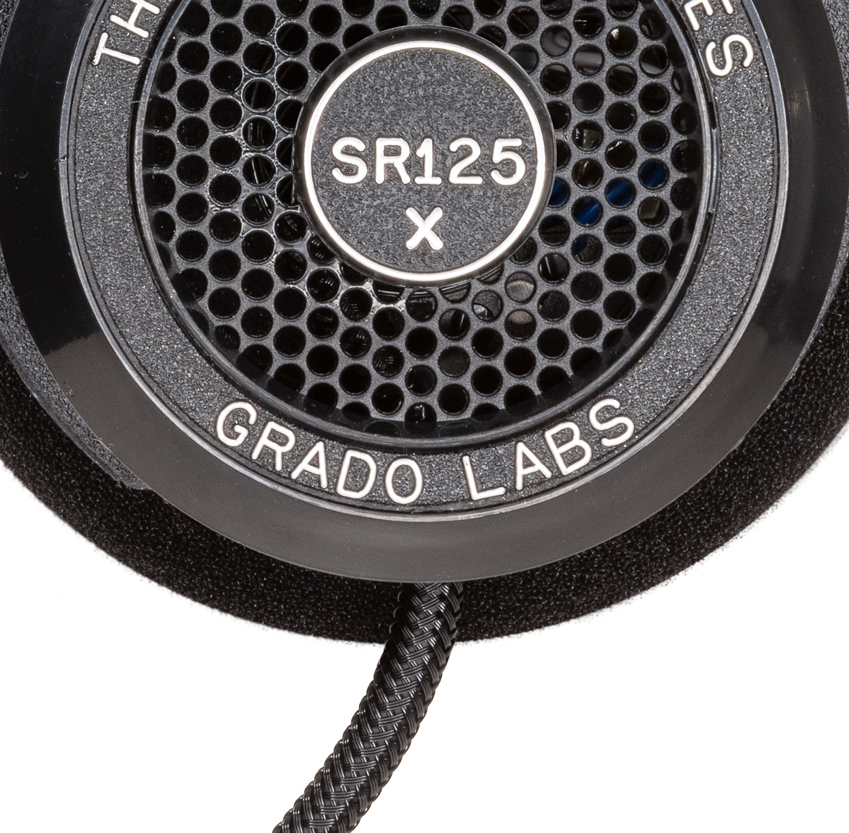 Close up photo of the Grado SR125x Headphones taken from the side - the model name - SR125x - is featured in the center of the ear cup. The Words - The Prestige Series - and - Grado Labs are written around the outer edge of the ear cup.