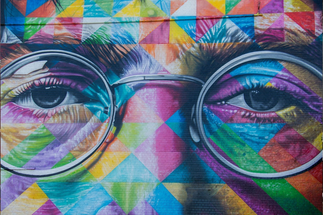 Close up photo of a colorful mural of John Lennon's Eyes and nose.