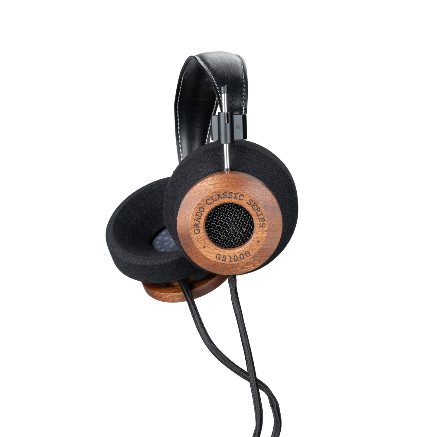 Photo of Grado GS1000 Headphones on a white background taken from the 3/4 view - One ear cup is facing down while the other ear cup is facing outward - the words - Grado Classic Series - and - GS1000 - can be seen on the ear cup.
