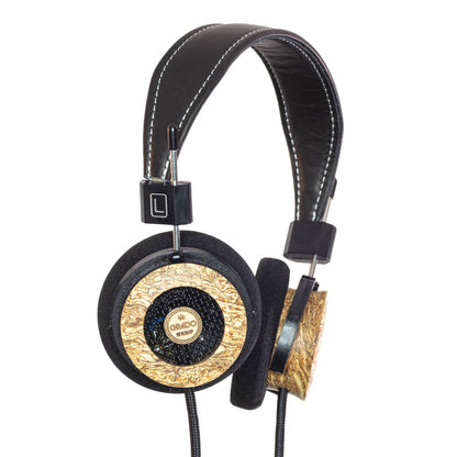 Photo of Grado Hemp Headphones  taken from 3/4 view - one ear cup is facing away from view while the other is showing the Grado logo in the center. The cables can be seen coming out of the headphone.