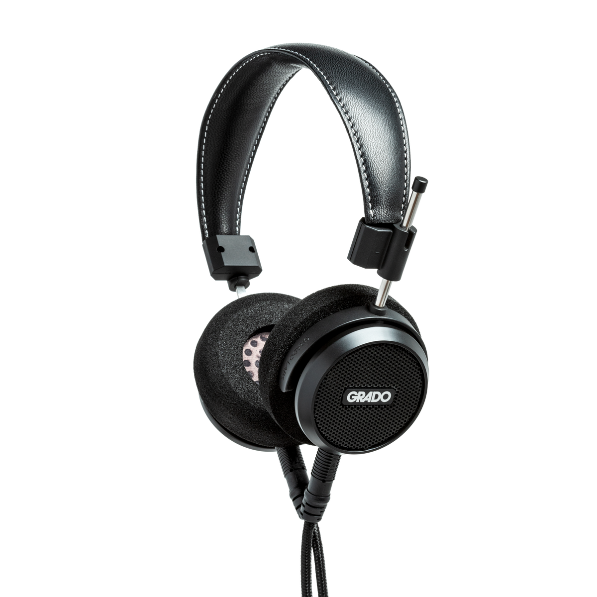 Photo of Grado S150 Headphones taken from the 3/4 view - the Grado logo is featured in the center of the ear cup and the black cables can be seen coming out of the headphone.